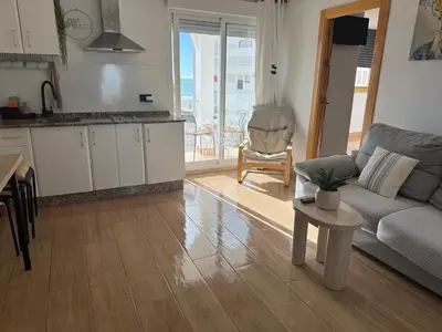 a living room with a couch and a table at Valdelagrana vistas al mar, piscinas primera linea cadiz in El Puerto de Santa María