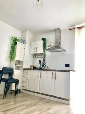 a kitchen with white cabinets and a table and chairs at Valdelagrana vistas al mar, piscinas primera linea cadiz in El Puerto de Santa María