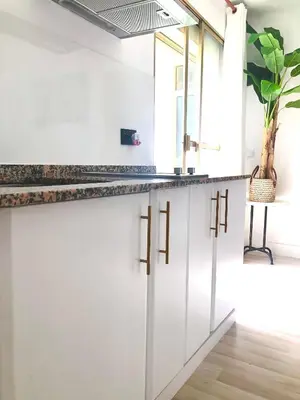 a kitchen with white cabinets and a potted plant at Valdelagrana vistas al mar, piscinas primera linea cadiz in El Puerto de Santa María