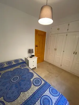 a bedroom with a blue and white bed and a lamp at Apartamento Costa de la Luz - Parking y Terraza in Chipiona