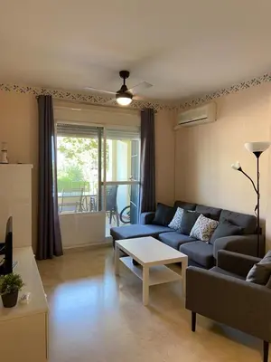 a living room with a blue couch and a table at Apartamento Costa de la Luz - Parking y Terraza in Chipiona