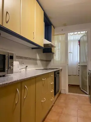 a kitchen with yellow cabinets and a counter top at Apartamento Costa de la Luz - Parking y Terraza in Chipiona
