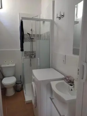 a white bathroom with a toilet and a sink at El Tabanquito in Jerez de la Frontera