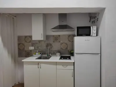 a white kitchen with a refrigerator and a microwave at El Tabanquito in Jerez de la Frontera