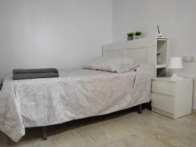 a bedroom with a bed and a night stand at El Tabanquito in Jerez de la Frontera