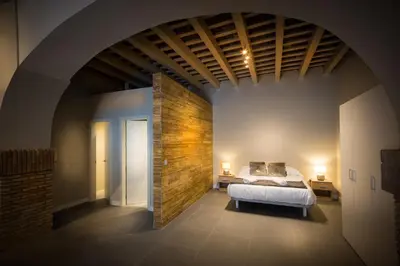 a bedroom with a bed and a brick wall at LOFT LA CATEDRAL - Parking disponible in Jerez de la Frontera