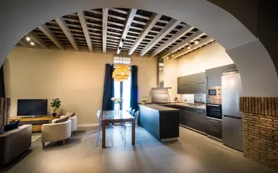 a kitchen and living room with a table and a couch at LOFT LA CATEDRAL - Parking disponible in Jerez de la Frontera