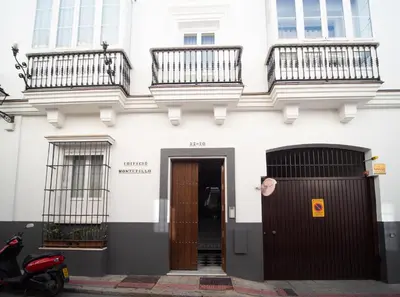 a white building with two balconies and a door at Apartamento Montefillo in Sanlúcar de Barrameda