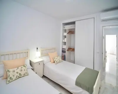 a bedroom with two beds and a closet at Apartamento Montefillo in Sanlúcar de Barrameda
