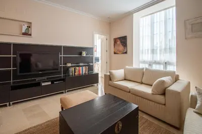a living room with a couch and a tv at Apartamento El Meridiano de Cadiz in Cádiz