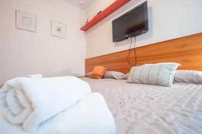 a bedroom with a bed with a flat screen tv on the wall at Apartamento El Meridiano de Cadiz in Cádiz