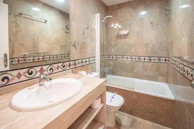 a bathroom with a sink and a tub and a toilet at Apartamento El Meridiano de Cadiz in Cádiz