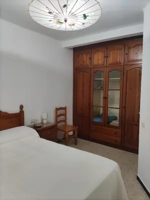 a bedroom with a bed and a chandelier at Comparte Espacio en Chiclana in Chiclana de la Frontera