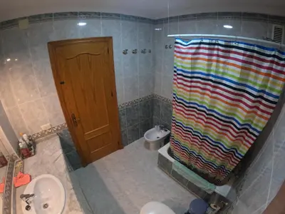 a bathroom with a shower with a colorful shower curtain at Comparte Espacio en Chiclana in Chiclana de la Frontera