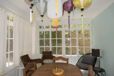 a dining room with a table and chairs and windows at Chalet El Girasol in Chiclana de la Frontera
