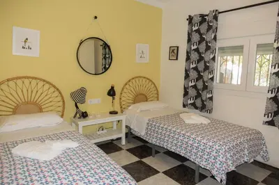 a bedroom with two beds and a mirror at Chalet El Girasol in Chiclana de la Frontera