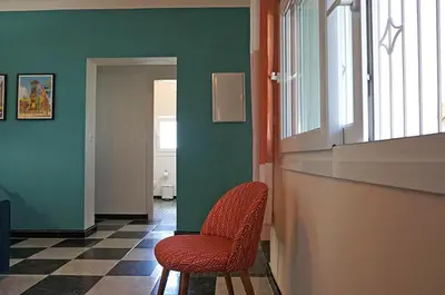 a room with two chairs and a counter and green walls at Chalet El Girasol in Chiclana de la Frontera
