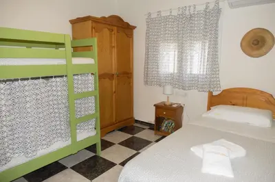 a bedroom with a green bunk bed and a checkered floor at Chalet El Girasol in Chiclana de la Frontera