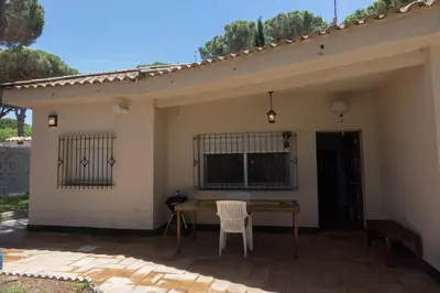 a patio with a table and chairs and a window at Chalet El Girasol in Chiclana de la Frontera