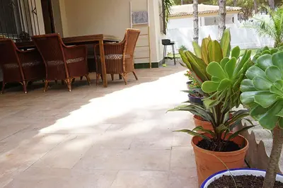 a patio with a table and chairs and plants at Chalet El Girasol in Chiclana de la Frontera