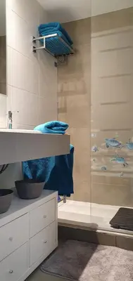 a bathroom with a glass shower with blue towels at Rota Mar in Rota