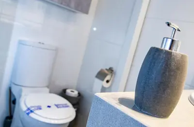 a bathroom with a toilet and a holder on a counter at Rota Mar in Rota