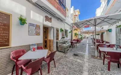 an outdoor restaurant with tables and chairs and umbrellas at Rota Mar in Rota
