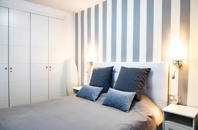a bedroom with a bed with blue pillows at Rota Mar in Rota