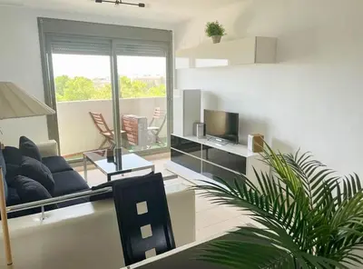 a living room with a couch and a tv at Apartamento moderno con vistas in El Puerto de Santa María