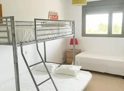 a bedroom with two bunk beds and a window at Apartamento moderno con vistas in El Puerto de Santa María