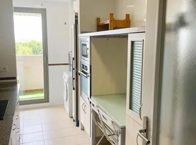 a kitchen with a stove and a refrigerator at Apartamento moderno con vistas in El Puerto de Santa María