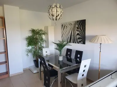 a dining room with a table with chairs and plants at Apartamento moderno con vistas in El Puerto de Santa María