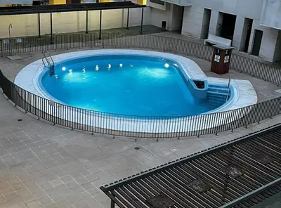 a large blue swimming pool in a building at Apartamento moderno con vistas in El Puerto de Santa María