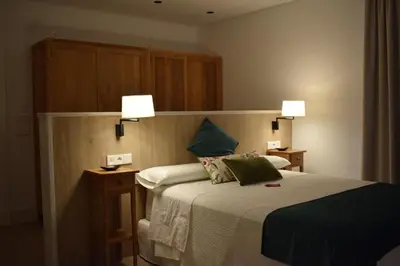 a bedroom with a bed with two lamps on it at Apartamentos Turísticos La Plaza in Chipiona