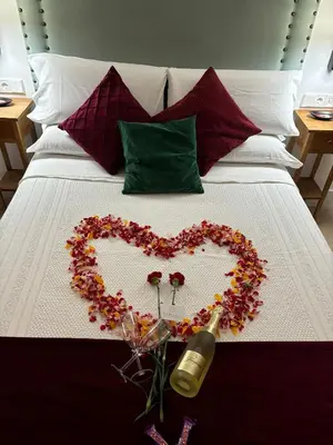 a heart made out of flowers on a bed at Apartamentos Turísticos La Plaza in Chipiona