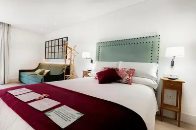 a hotel room with a large bed and a chair at Apartamentos Turísticos La Plaza in Chipiona