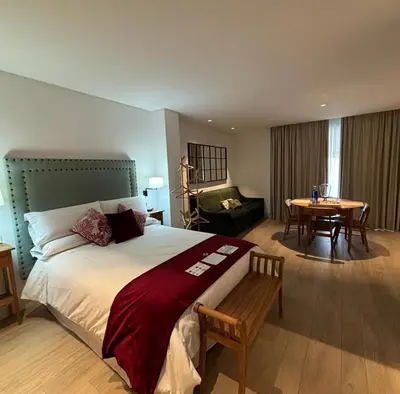 a bedroom with a large bed with a table and a chair at Apartamentos Turísticos La Plaza in Chipiona