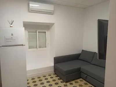 a waiting room with a couch and a tv at Apartamento Nayca in Jerez de la Frontera