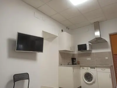 a kitchen with a washing machine and a tv on the wall at Apartamento Nayca in Jerez de la Frontera
