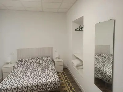 a white room with two beds and a mirror at Apartamento Nayca in Jerez de la Frontera