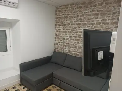 a couch in a room with a brick wall at Apartamento Nayca in Jerez de la Frontera