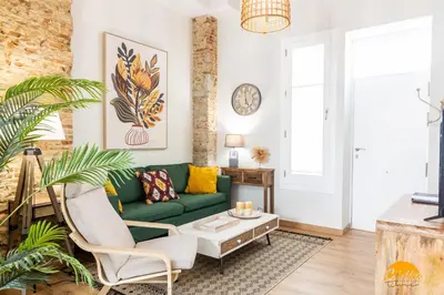 a living room with a green couch and a coffee table at Nature Home by Cadiz Time in Cádiz