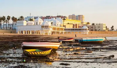 a group of boats sitting on the beach at El Patio de Santa María in Cádiz