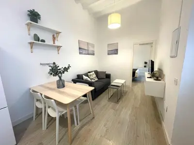 a living room with a table and a couch at El Patio de Santa María in Cádiz