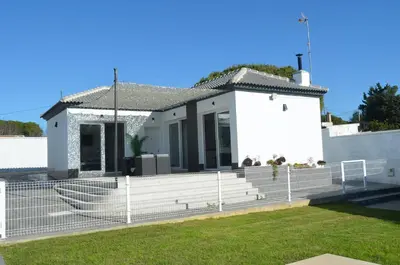 a white house with a fence in front of it at EL ENCANTO Chiclana II in Chiclana de la Frontera