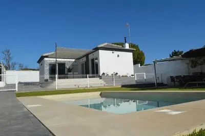 a house with a swimming pool in front of a house at EL ENCANTO Chiclana II in Chiclana de la Frontera