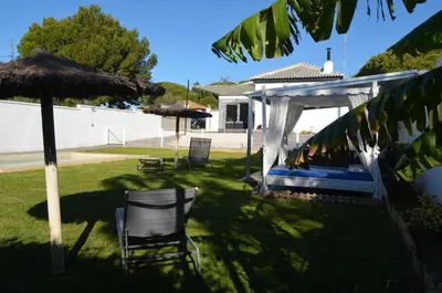 a backyard with a gazebo and two chairs and an umbrella at EL ENCANTO Chiclana II in Chiclana de la Frontera