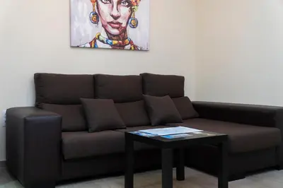 a couch and a table in a room with a painting at Casa Caleta in Cádiz