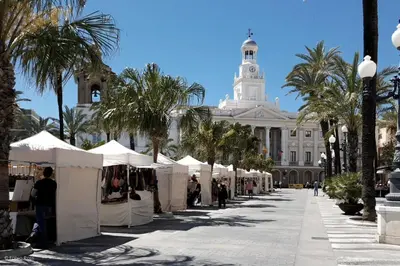 a street with white tents in front of a building at Casa Caleta in Cádiz