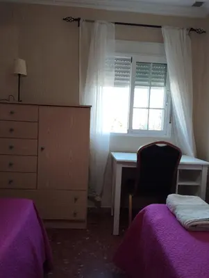 a bedroom with a bed and a desk and a window at Cadiz Rented in Cádiz